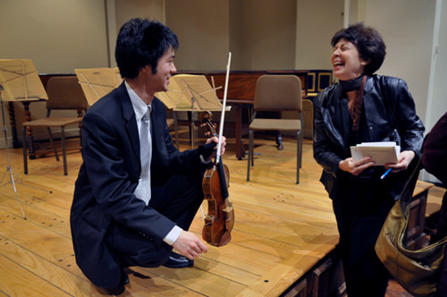 Post-concert, graduate student Francis Liu shares his experience playing the Greffuhle Strad with an audience member.
